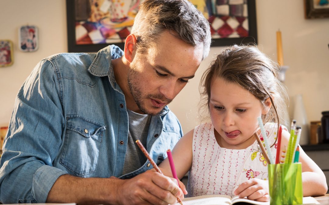 A dad helping his daughter with homework