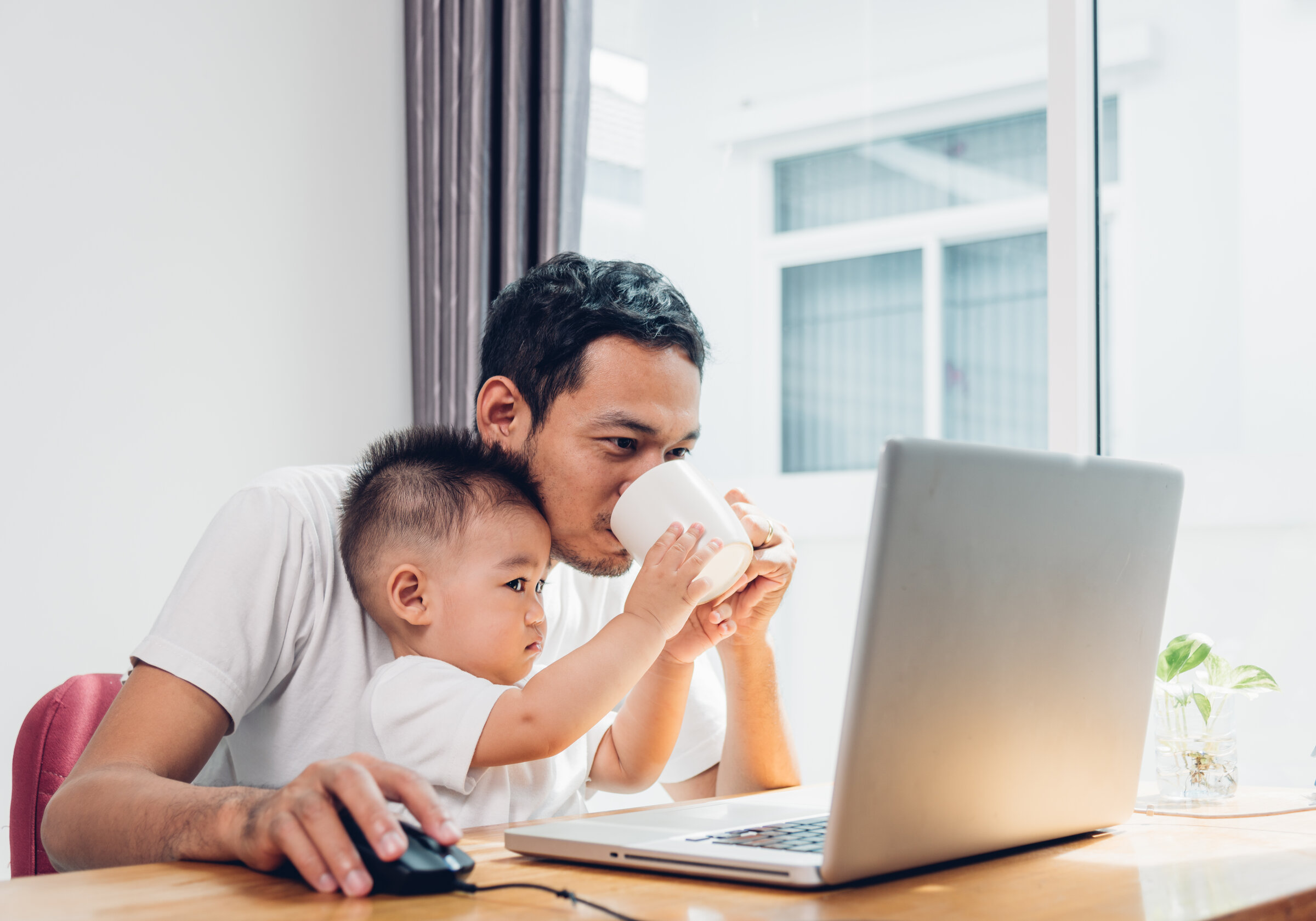 Dad working on laptop with son Free 3-Lesson Fatherhood Course to help dads stay calm, lead well and connect deeply